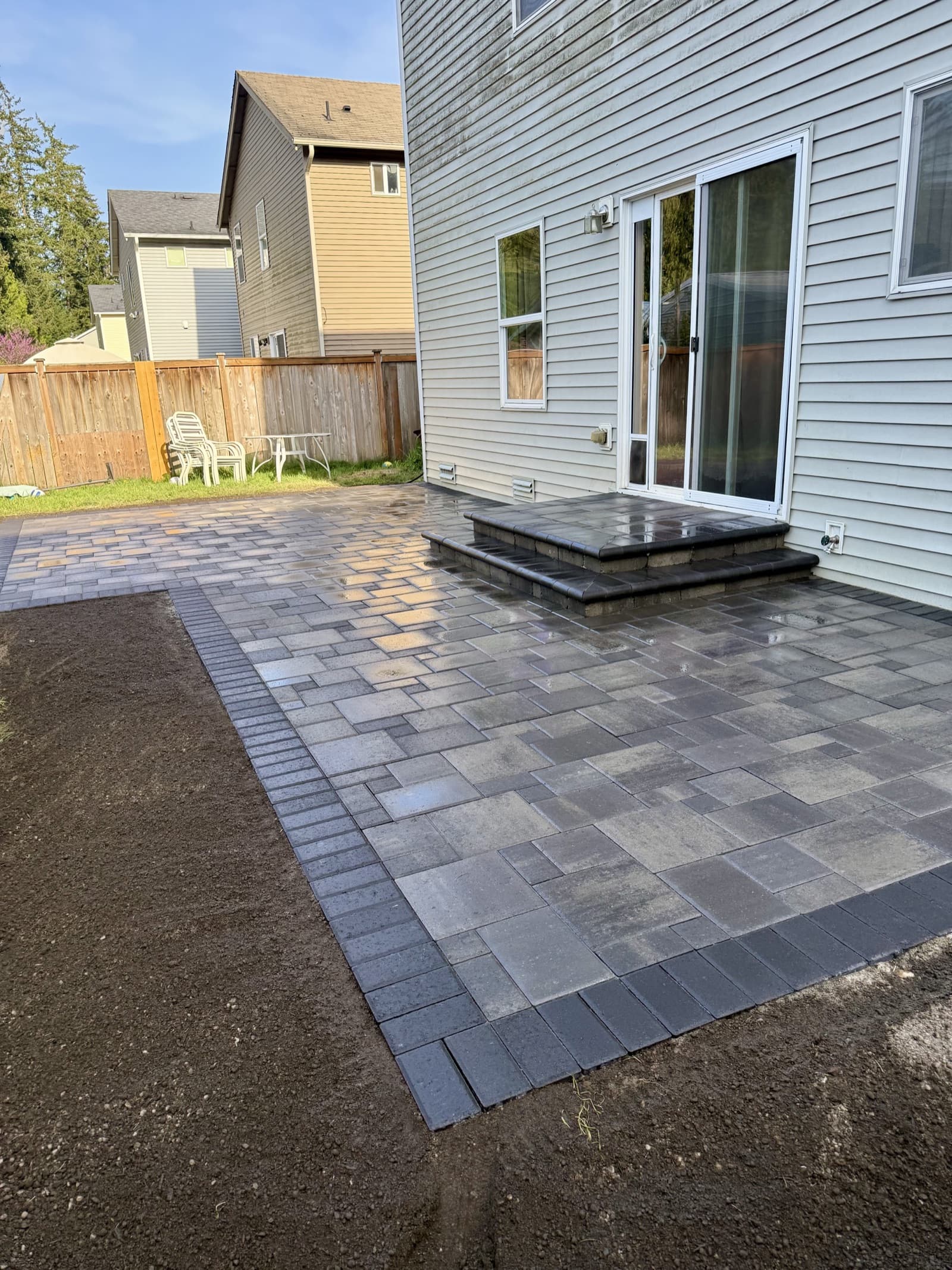 Custom paver patio installation with herringbone pattern in Tacoma backyard