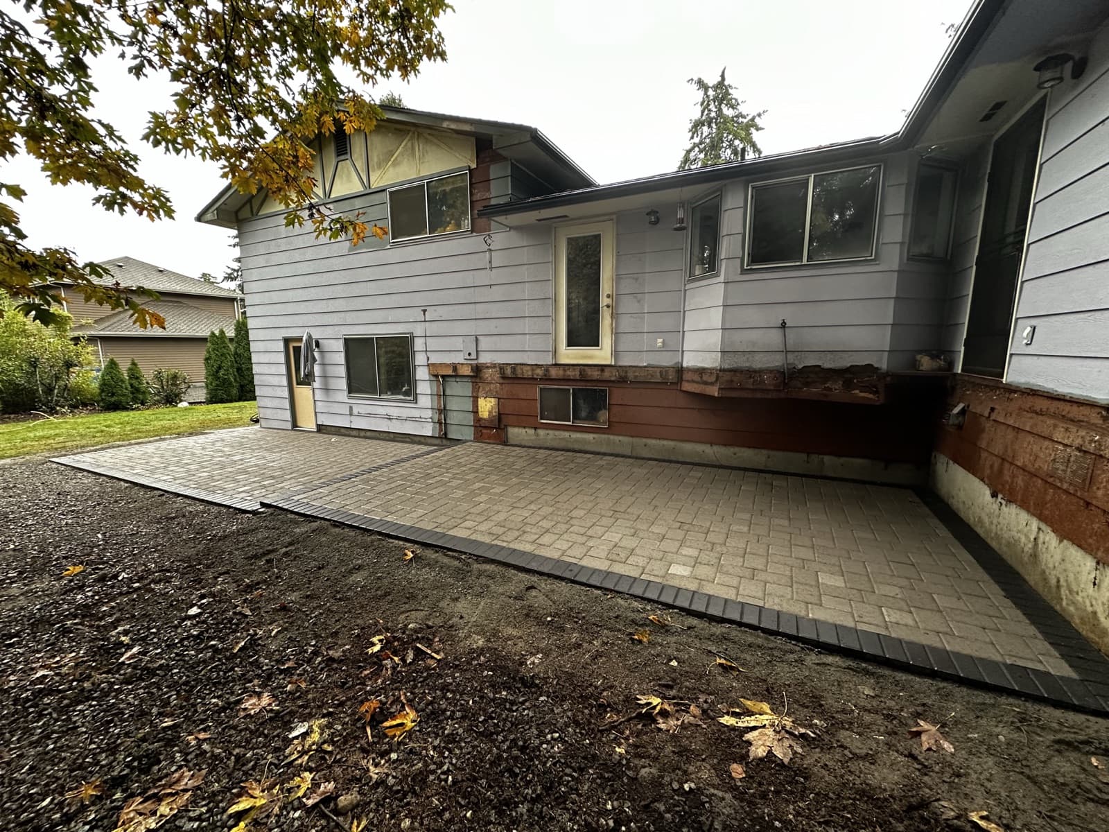 Expansive backyard paver patio with PNW landscaping