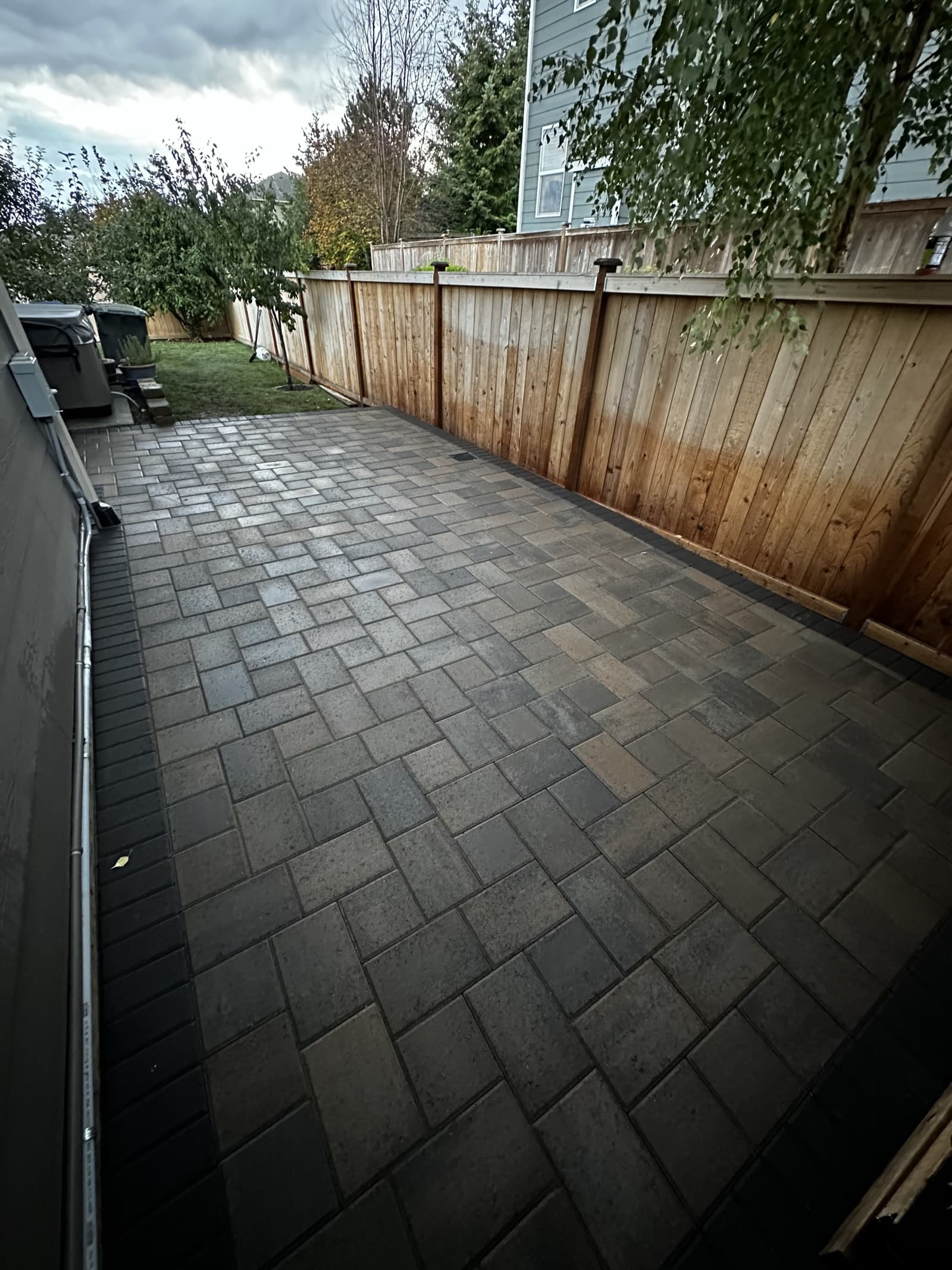 Large retaining wall creating level patio area on sloped lot