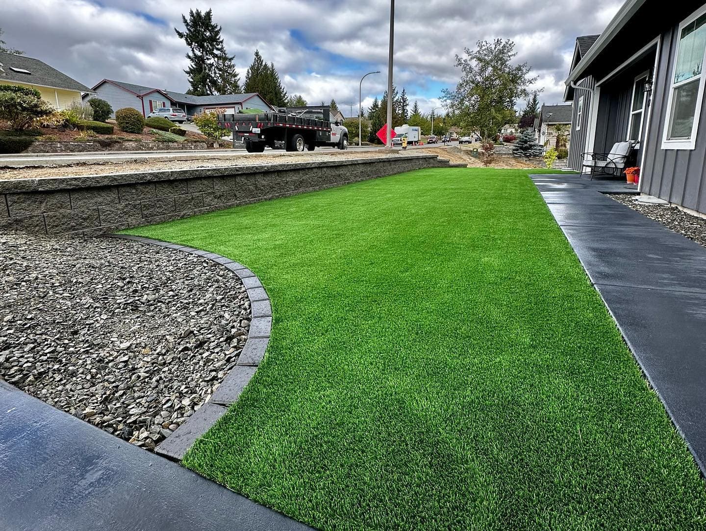 Artificial turf with retaining wall and stone edging